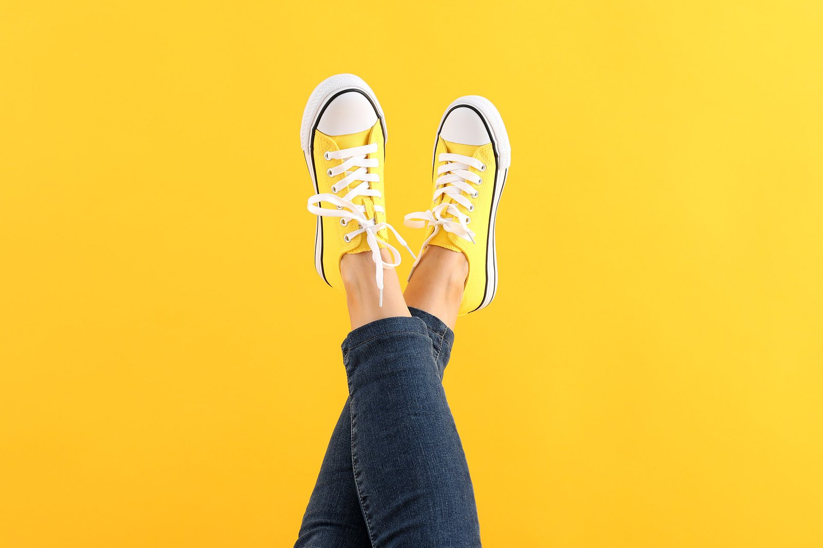 female-legs-in-jeans-and-sneakers-on-yellow-backgr-2022-01-30-07-07-58-utc.jpg